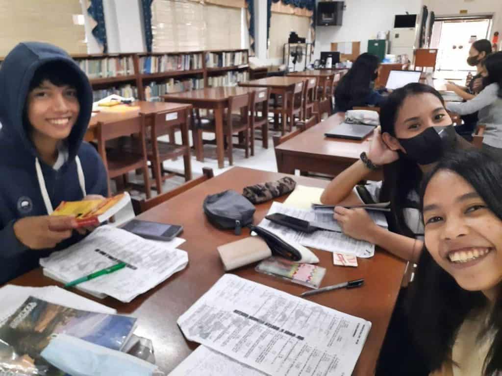 Students taking a selfie in a library